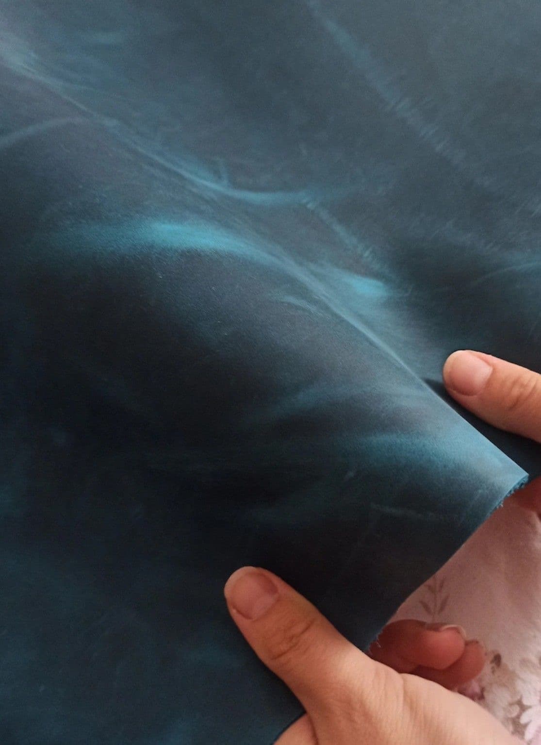 Blue-black leather held close for inspection.